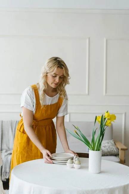 Personne utilisant un vaporisateur et un chiffon pour nettoyer une étagère de cuisine, en garantissant hygiène et propreté.